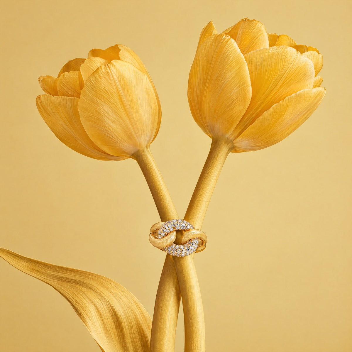 Agrafe Pavé Ring resting on two yellow tulip stems