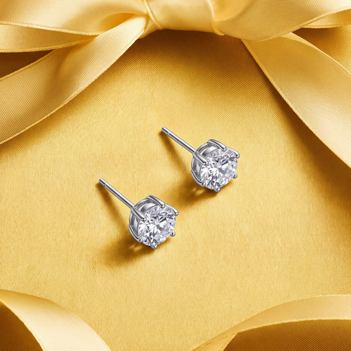 Prélude Moissanite Studs on a yellow satin bow